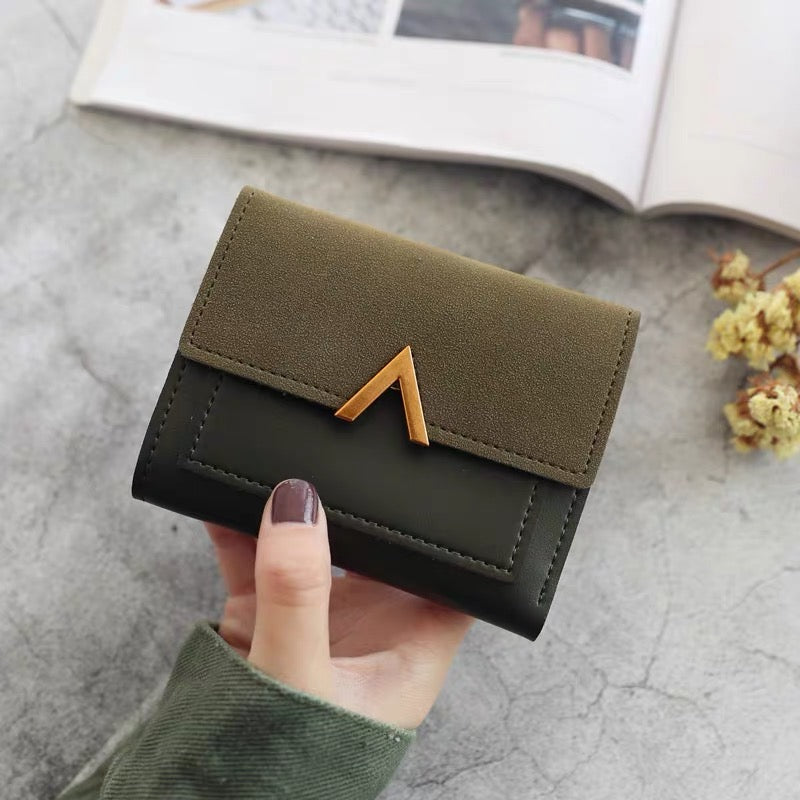 Model holding Small Wallet With Nubuck Leather Flap in green, ideal for commuting and gifting.
