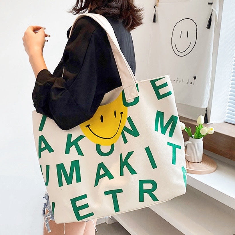 Model carrying a green smileface canvas tote bag on the shoulder, easy for commuting and weekends.