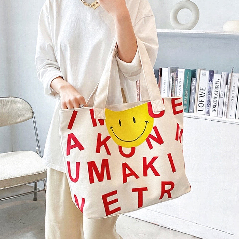 Model carring a Smileface Canvas Tote Bag in red, great for everyday carry and travel.
