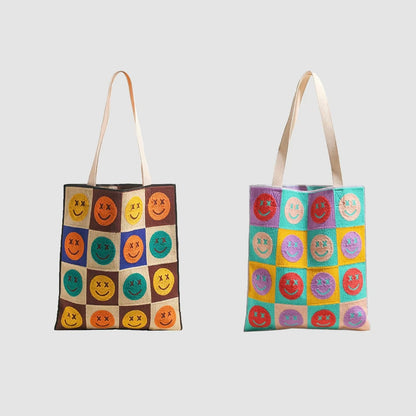 Two knitted tote bags, one brown plaid with colorful smiley faces, the other multi-color plaid with smiley faces.