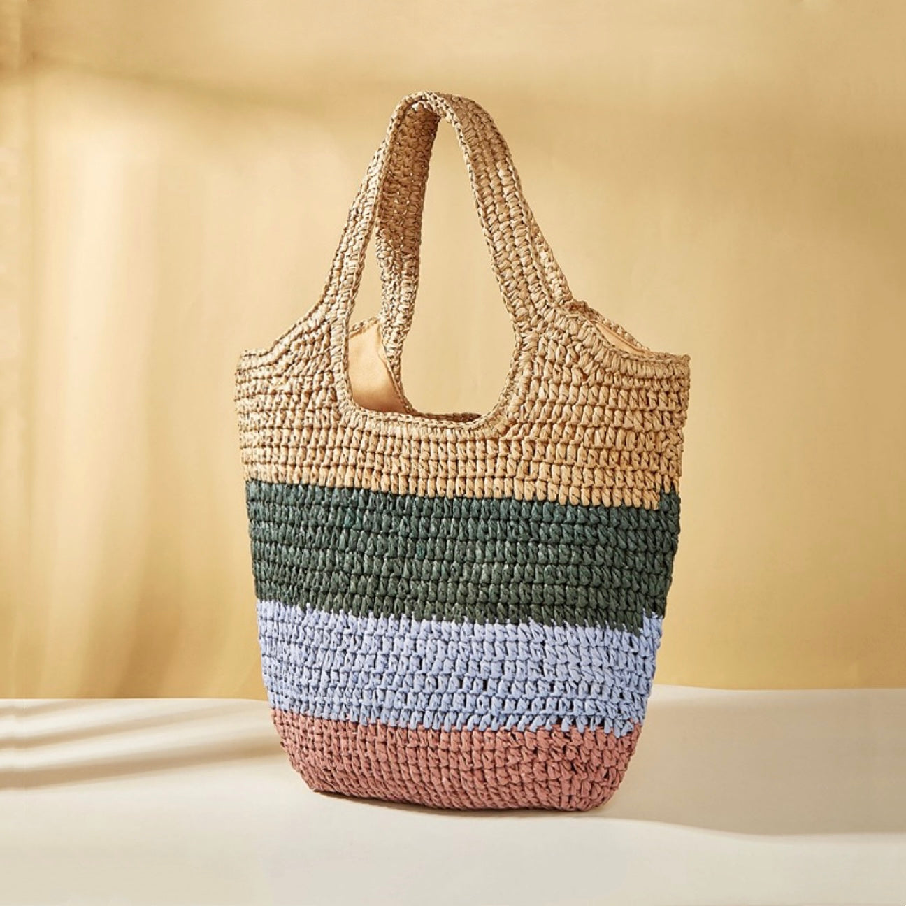 Stripe rattan straw tote bag with natural, green, light blue, and pink horizontal stripes.