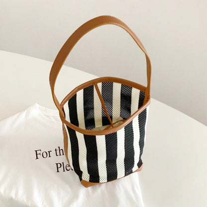 Folded view of Stripe Woven Bucket Bag, easy for commuting and weekends.