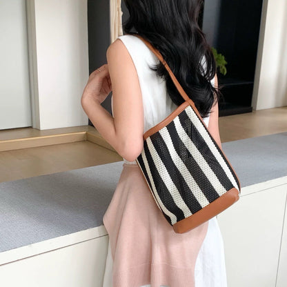 Model carrying a brown striped bag on the shoulder, great for daily carry and travel.