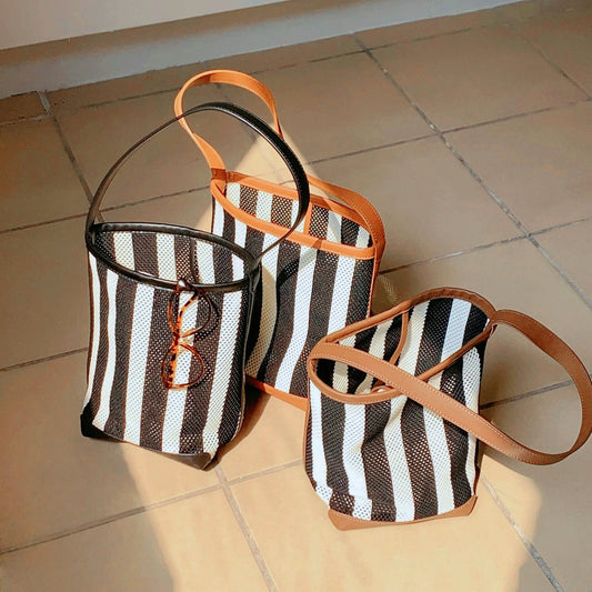 Front view of Three stripe woven bucket bags with PU leather trim and raffia straw.