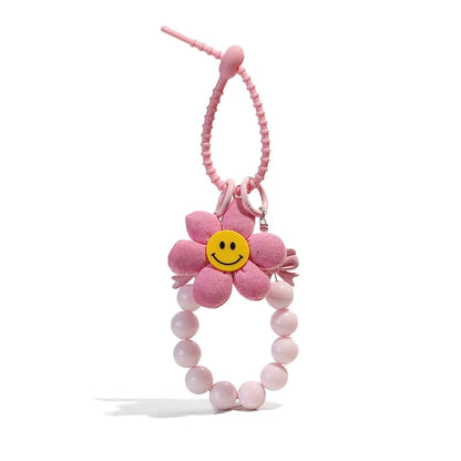 Front view of Pink flower bag charm with a yellow smiley face, beaded wristlet, and removable elements.