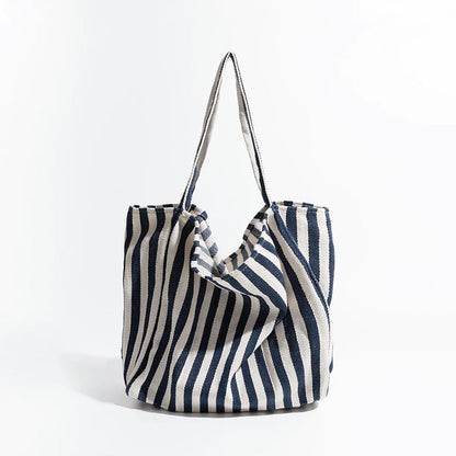 Front view of navy blue and white striped canvas tote, classic nautical look suited for outdoor picnics and boat trips.