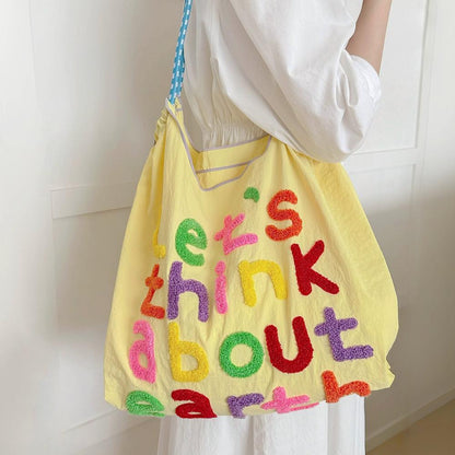 Model carrying a yellow Think About Earth Tote Bag on her shoulder, easy for commuting and weekends.