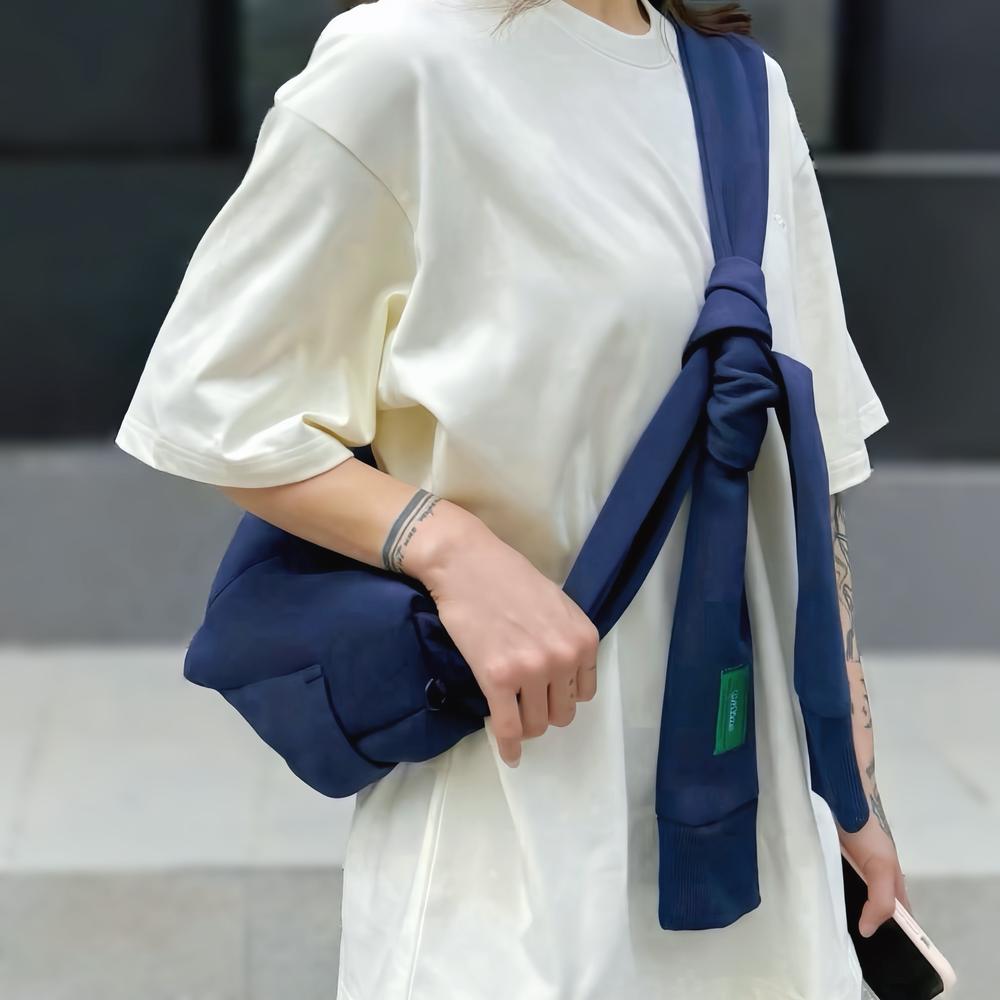 Model carrying a Twist & Tie Sleeve Bag as crossbody, ideal for city walks and gifting.