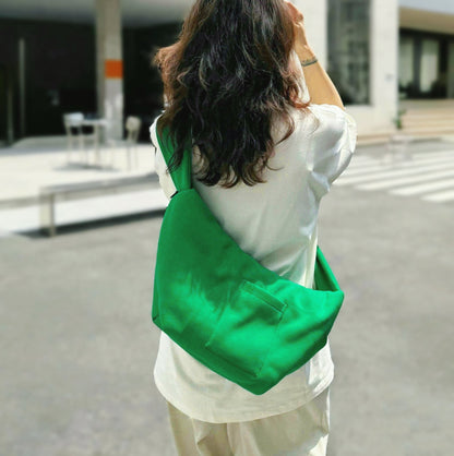 Model carrying a green Twist & Tie Sleeve Bag as crossbody, easy for commuting and weekends.