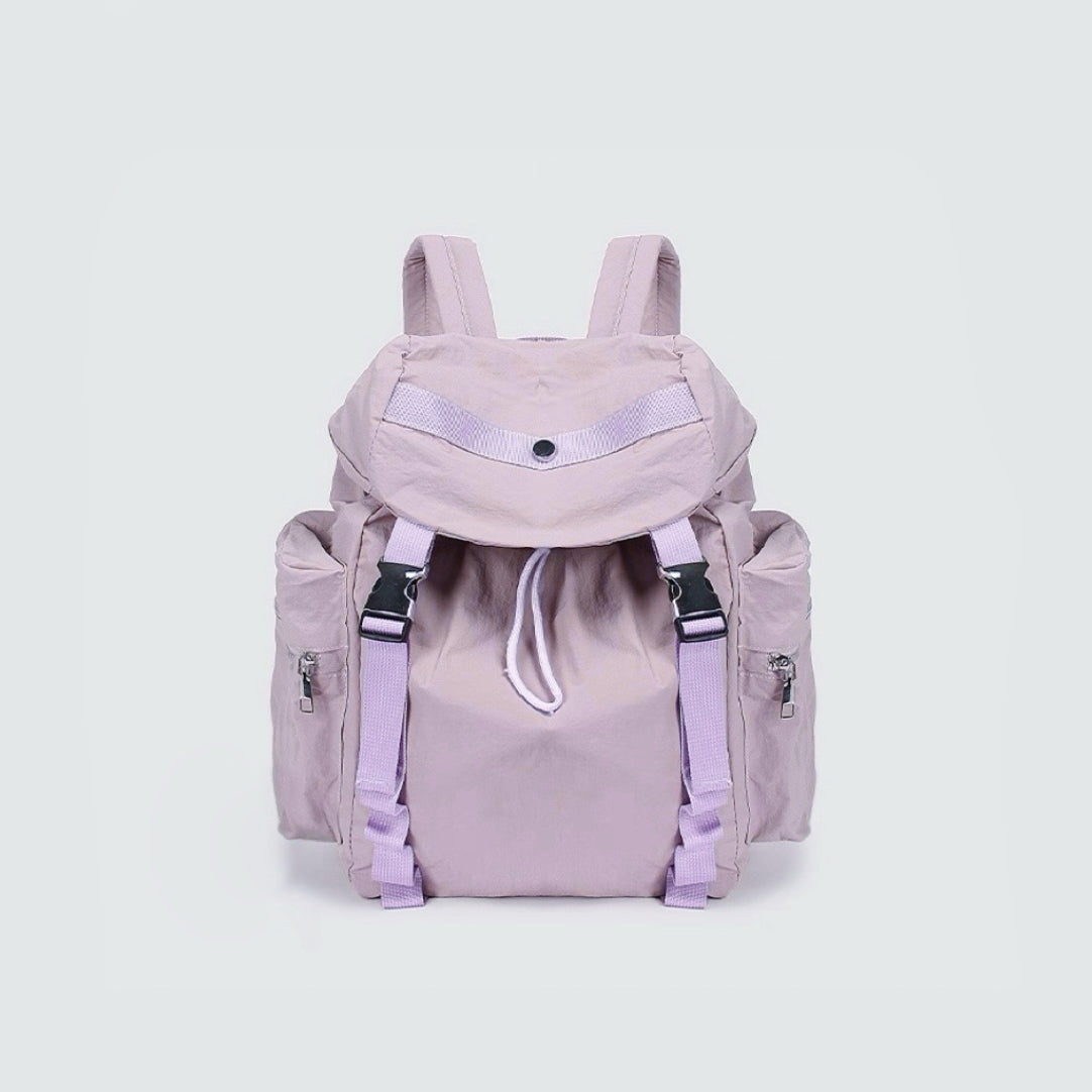 Angled view of Ultralight Urban Daily Backpack  in purple, showing compact width and flap design.