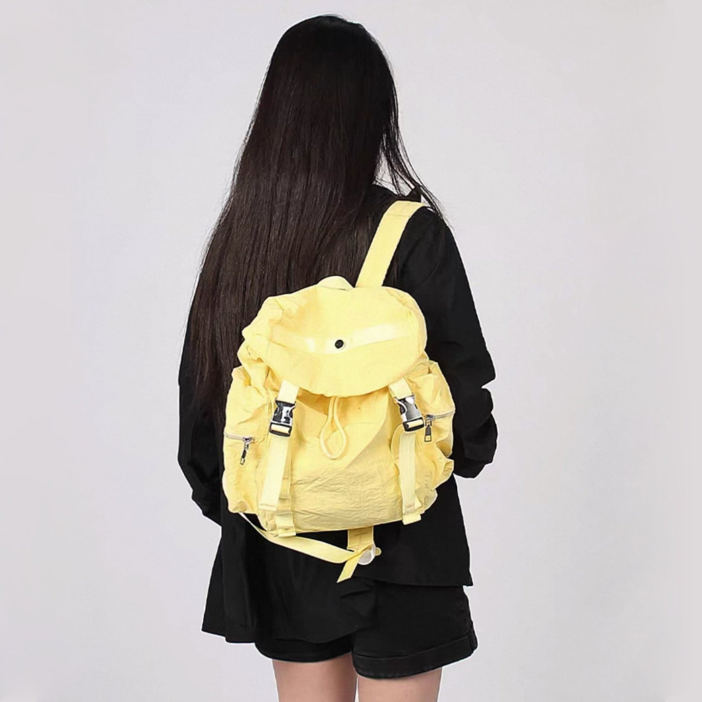 Model carrying a yellow  Ultralight Urban Daily Backpack, bright fashion lifestyle view.
