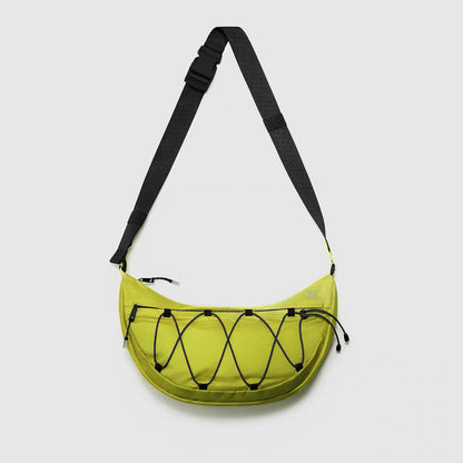 Close-up of the mustard nylon crossbody bag with a minimalist silhouette and bungee detail.