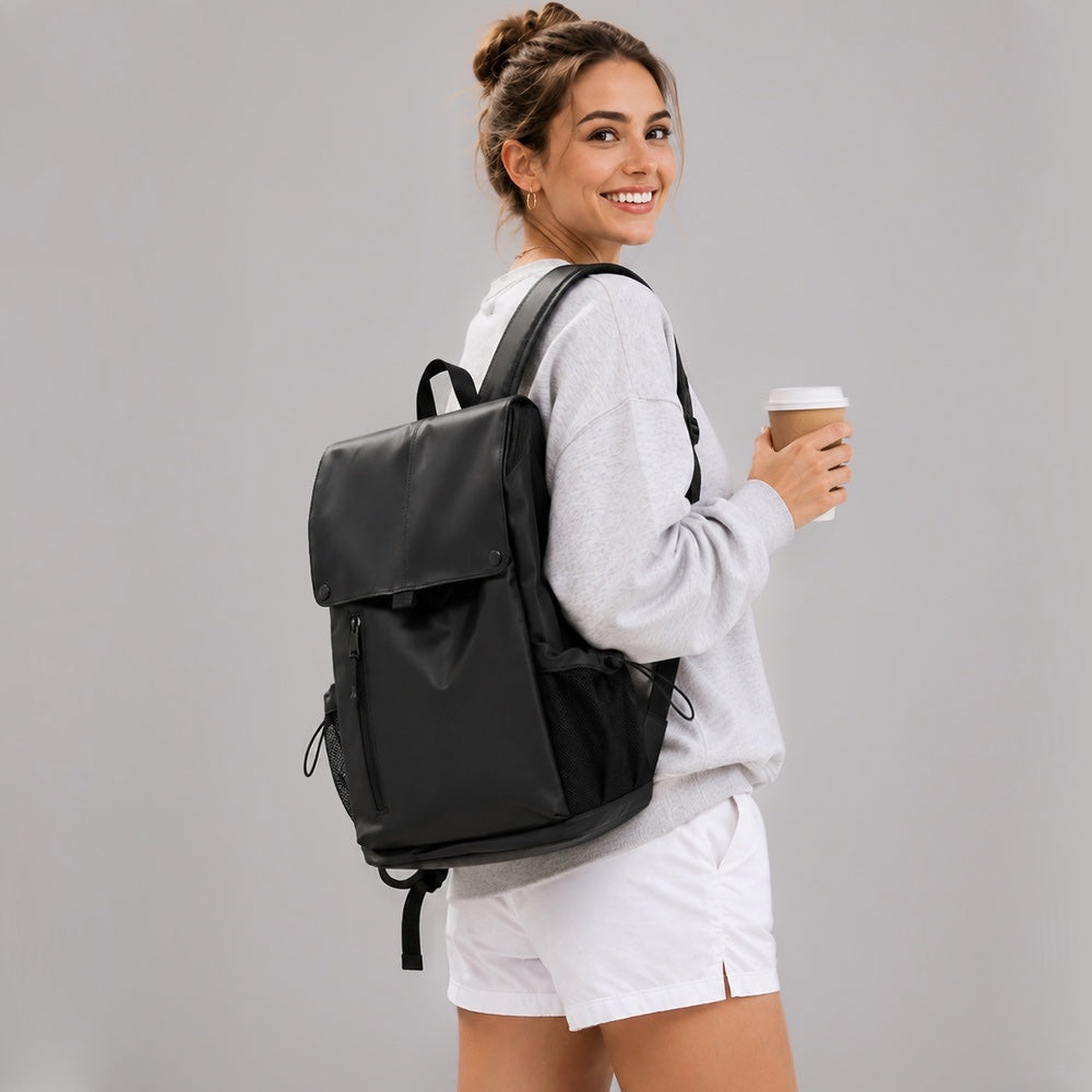 Model carrying the black urban waterproof flap backpack with coffee cup.