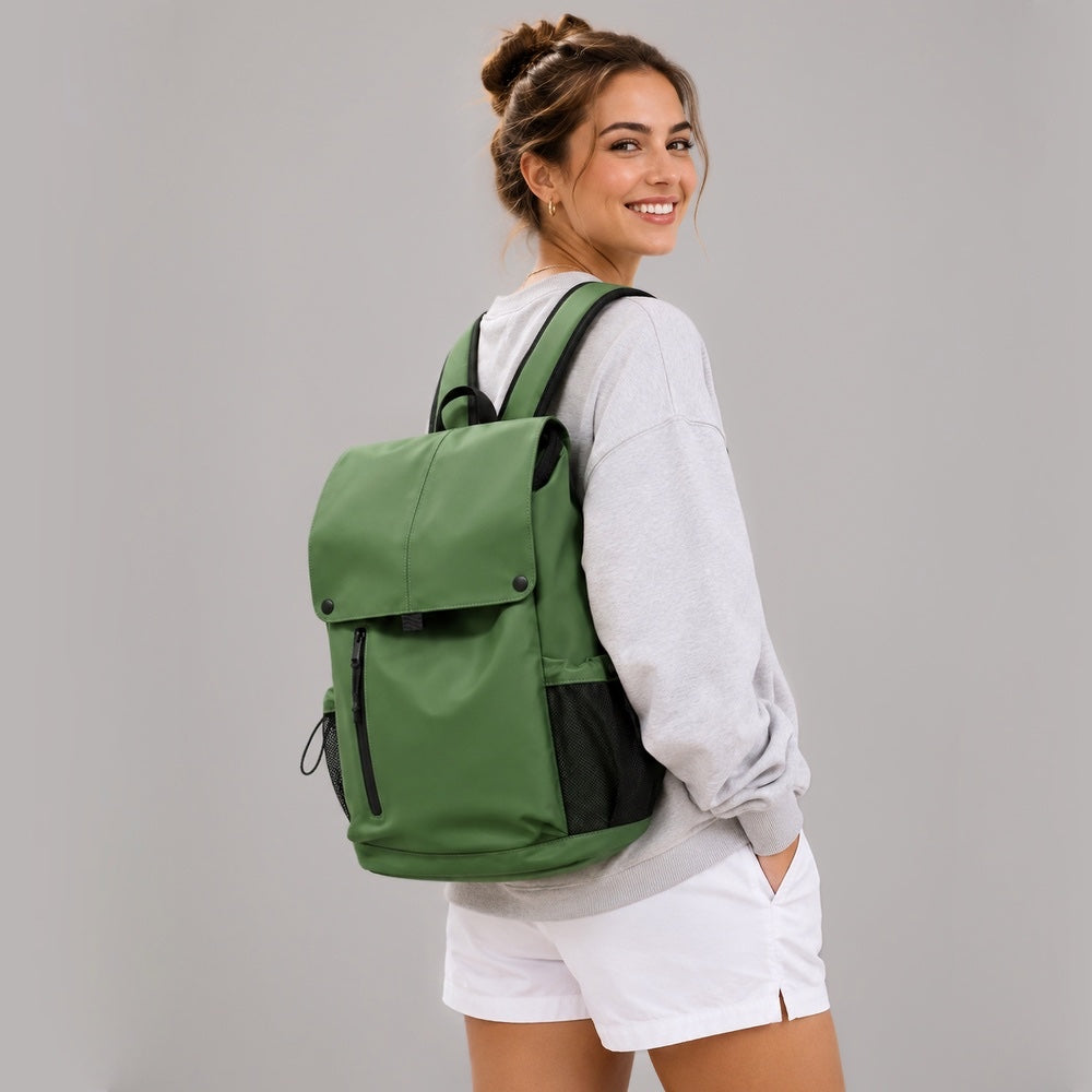 Model wearing the forest green flap laptop backpack on a city commute.