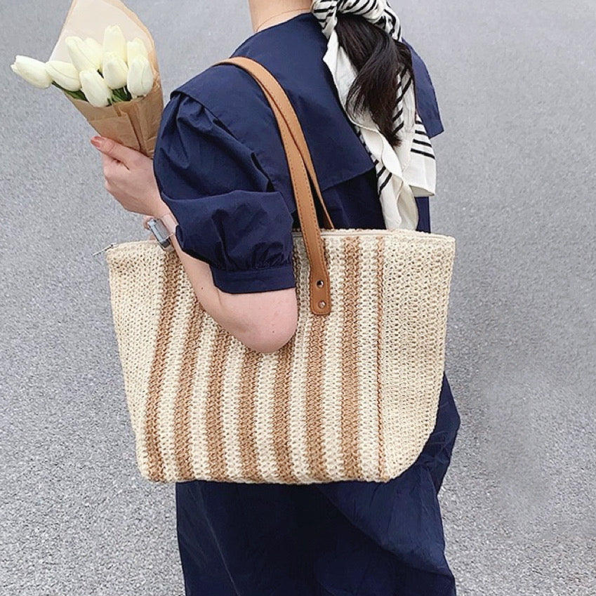 Model carrying a Vertical Striped Straw Tote Bag in khaki, ideal for city walks and gifting.