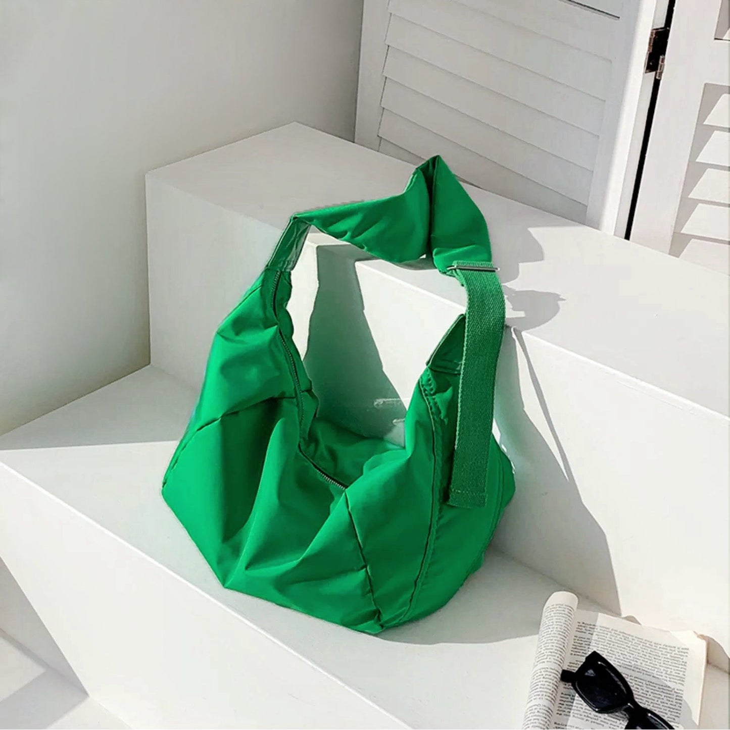 Vibrant green crescent bag with a cushioned texture, adding a pop of color to minimalist outfits.