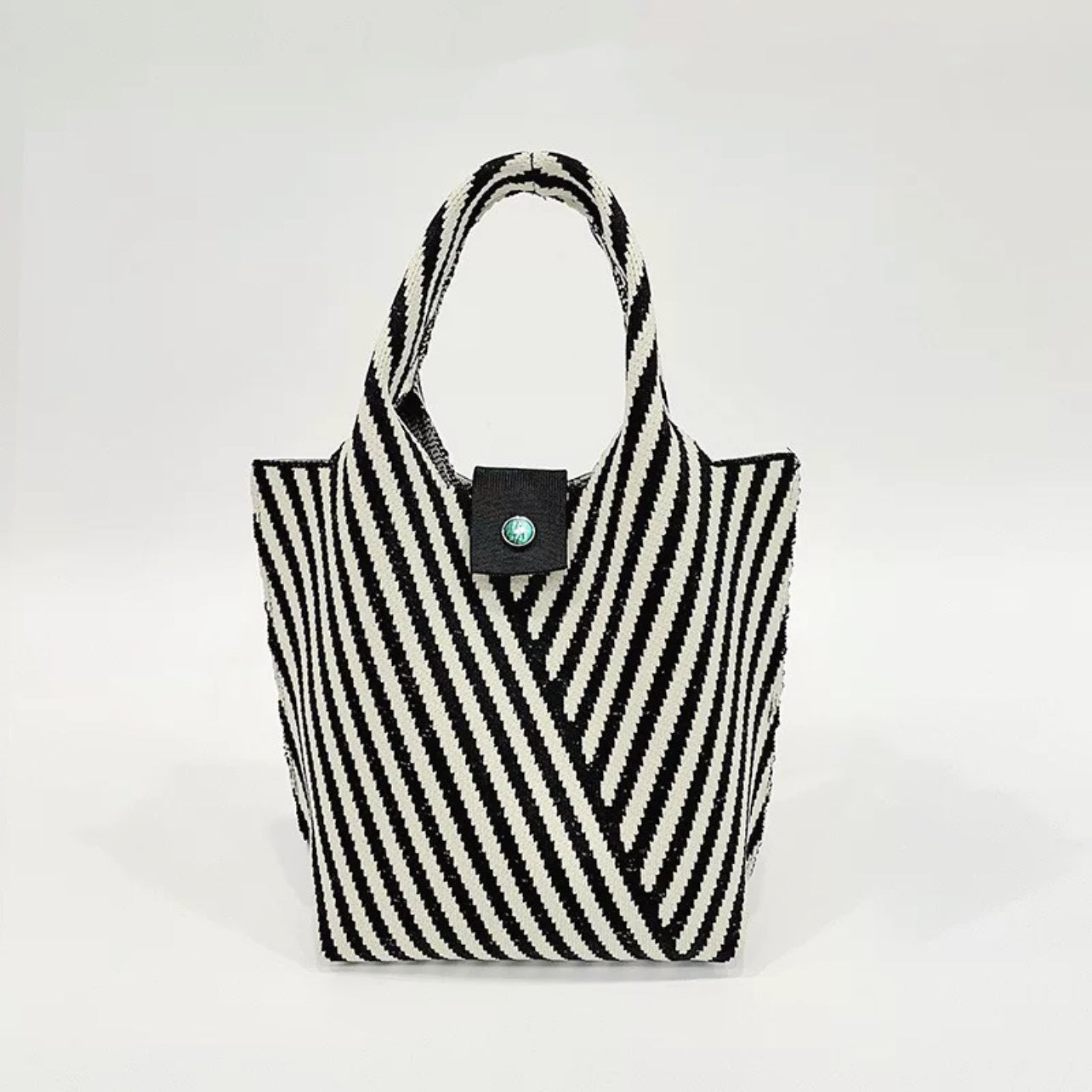 Angled view of Vintage striped knitted handbag in black.