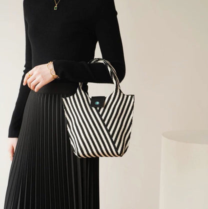 Model carrying a black Vintage Striped Knitted Handbag, great for daily carry and travel.