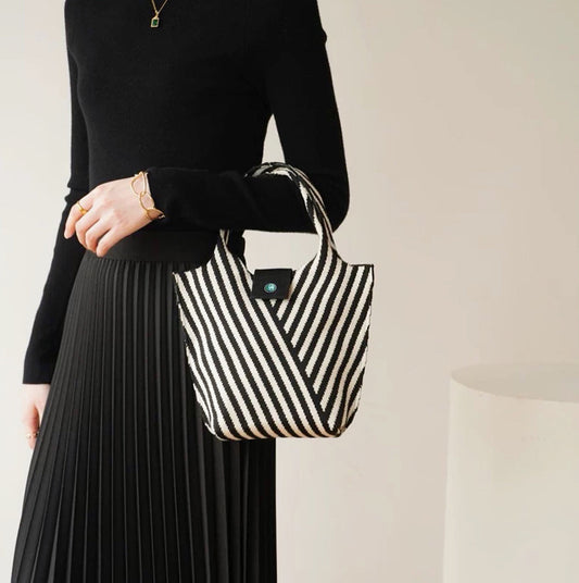 Model carrying a black Vintage Striped Knitted Handbag, great for daily carry and travel.