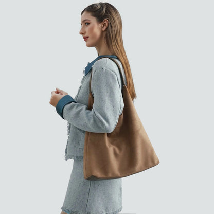 Camel vintage suede hobo bag worn as a minimalist daily shoulder bag.