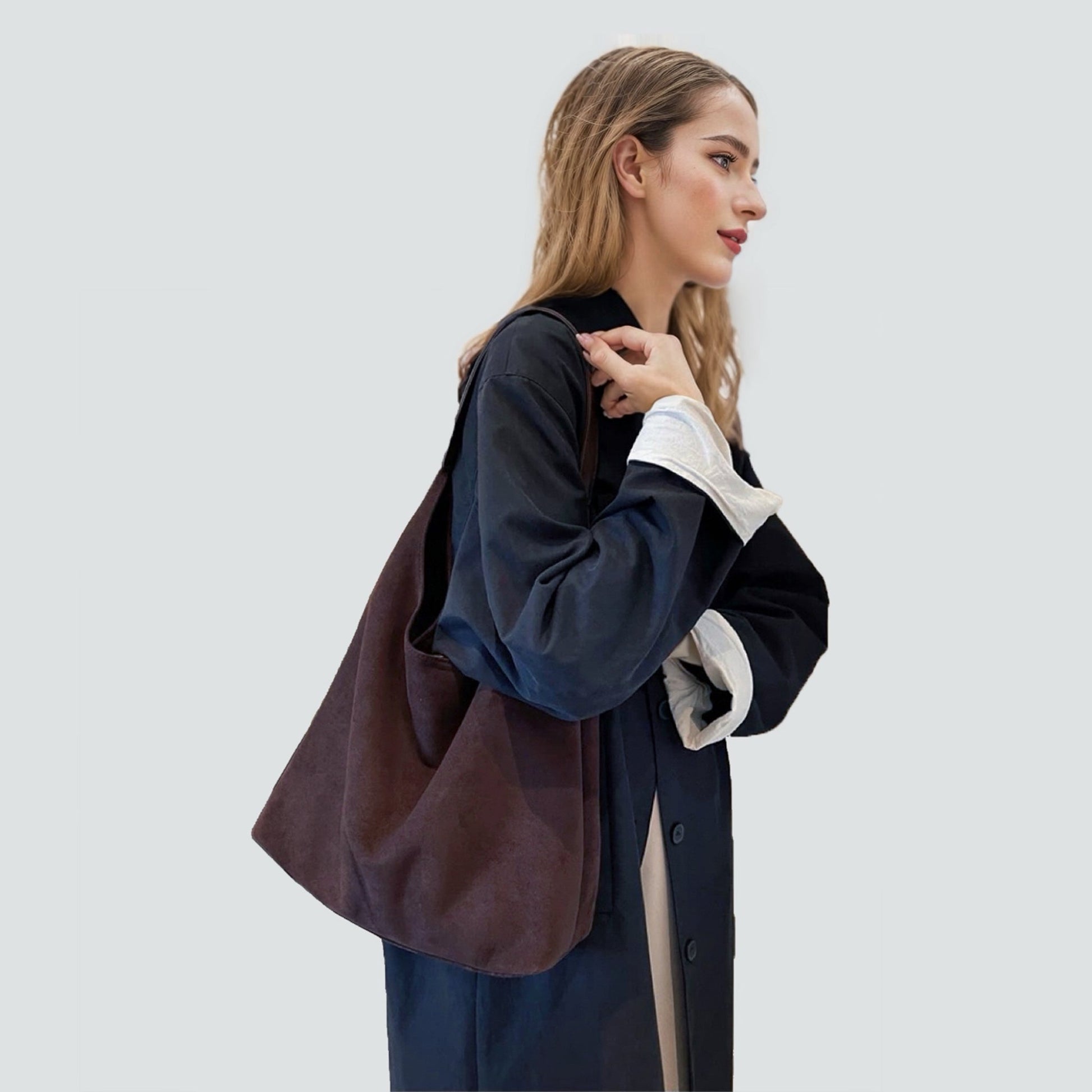 Dark brown vintage suede hobo bag carried by a model for a refined look.