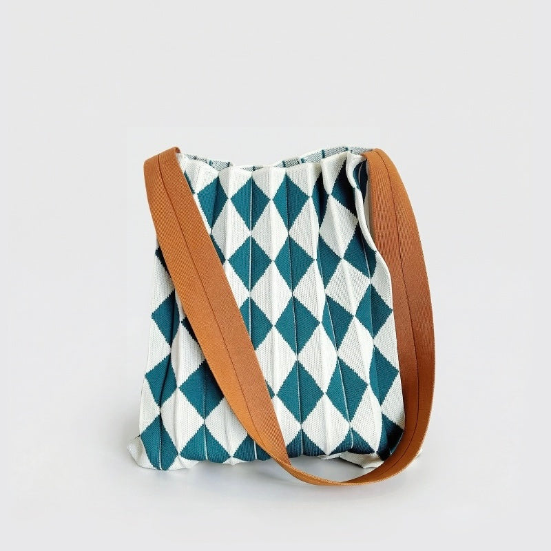 Close-up of Viridian-White argyle pleated knit bag, showcase stretchable fiber texture and pleated argyle pattern.