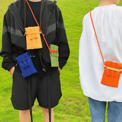 One model carrying an orange mini bag as crossbody, and the other model carrying blue, yellow and green bags.