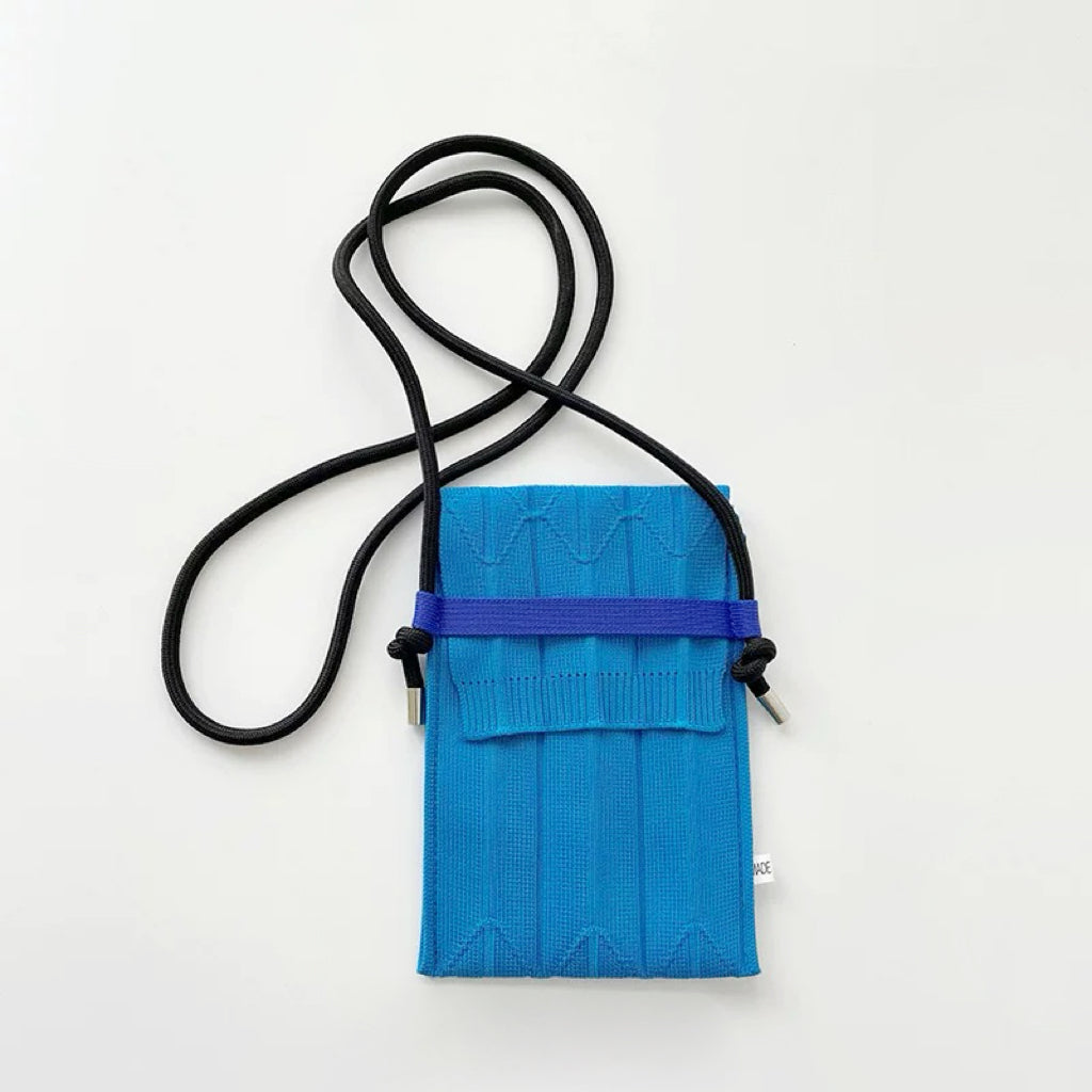Close-up of Vivid Knit Pleat Mini Bag in bright light blue, great for everyday carry and travel.