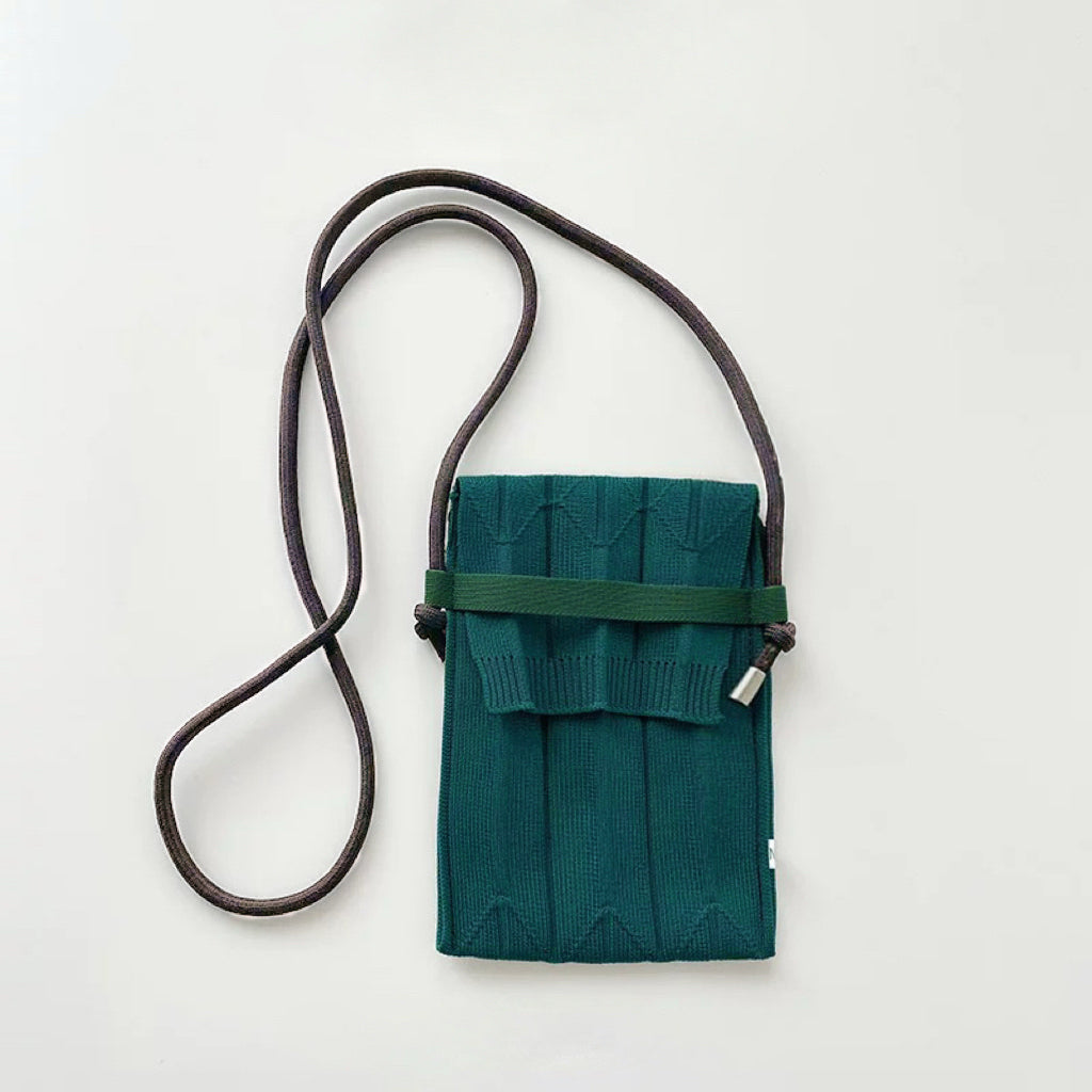 Flat lay of Vivid Knit Pleat Mini Bag in teal, easy for commuting and weekends.