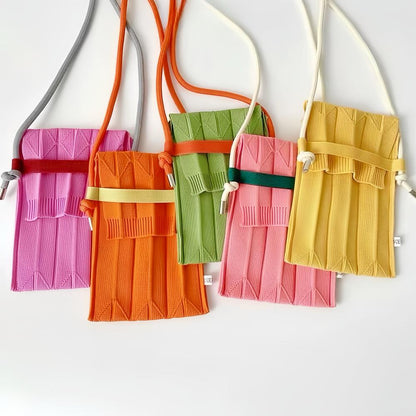 Front view of Five vivid knit polyester mini bags in pink, orange, green, and yellow with adjustable crossbody straps.