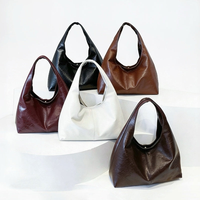 Five waxed leather hobo bags in different colors on a white background