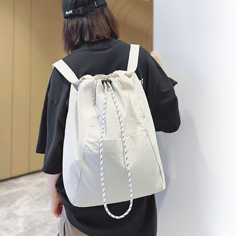 A model wearing the white water-resistant backpack, showcasing the comfortable backpack straps for outdoor ease.