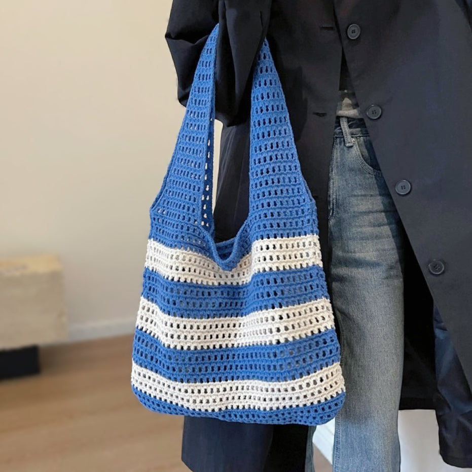 Model carrying a  Wide Stripe Crochet Bag in blue handheld, great for everyday carry and travel.