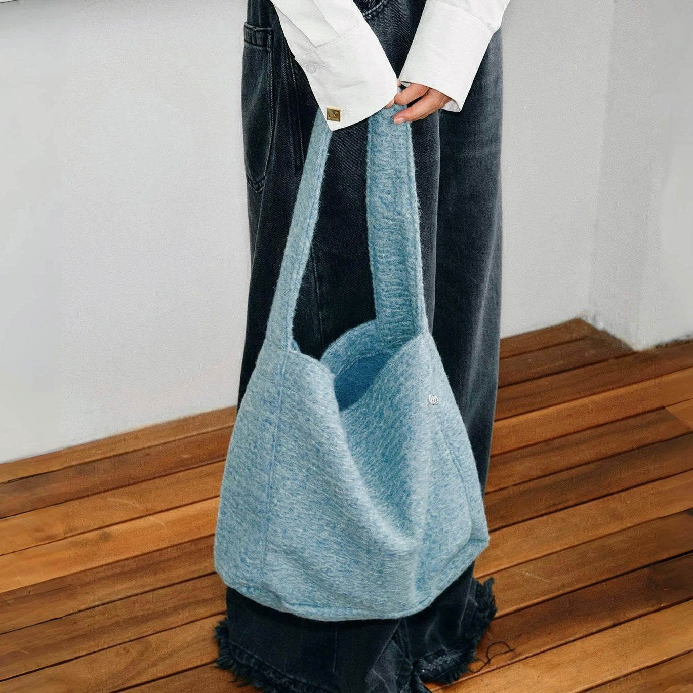 Model carrying a Woolish Cozy Tote Bag in blue handheld, easy for commuting and weekends.