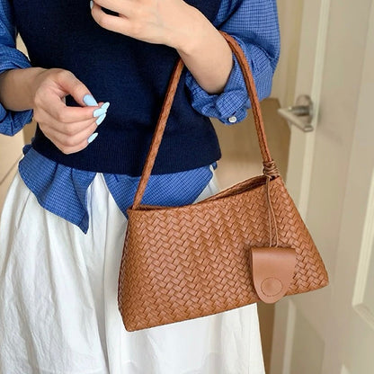 Model carrying a tan bag handheld, easy for commuting and weekends.