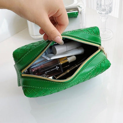 Model holding a Woven Leather Makeup Bag, showing the interior.