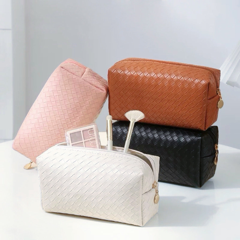 Front view of Four woven PU leather makeup bags: pink, brown, black, and white.