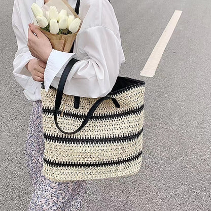Model carring a Woven Straw Tote Bag with Black Stripe, great for everyday carry and travel.