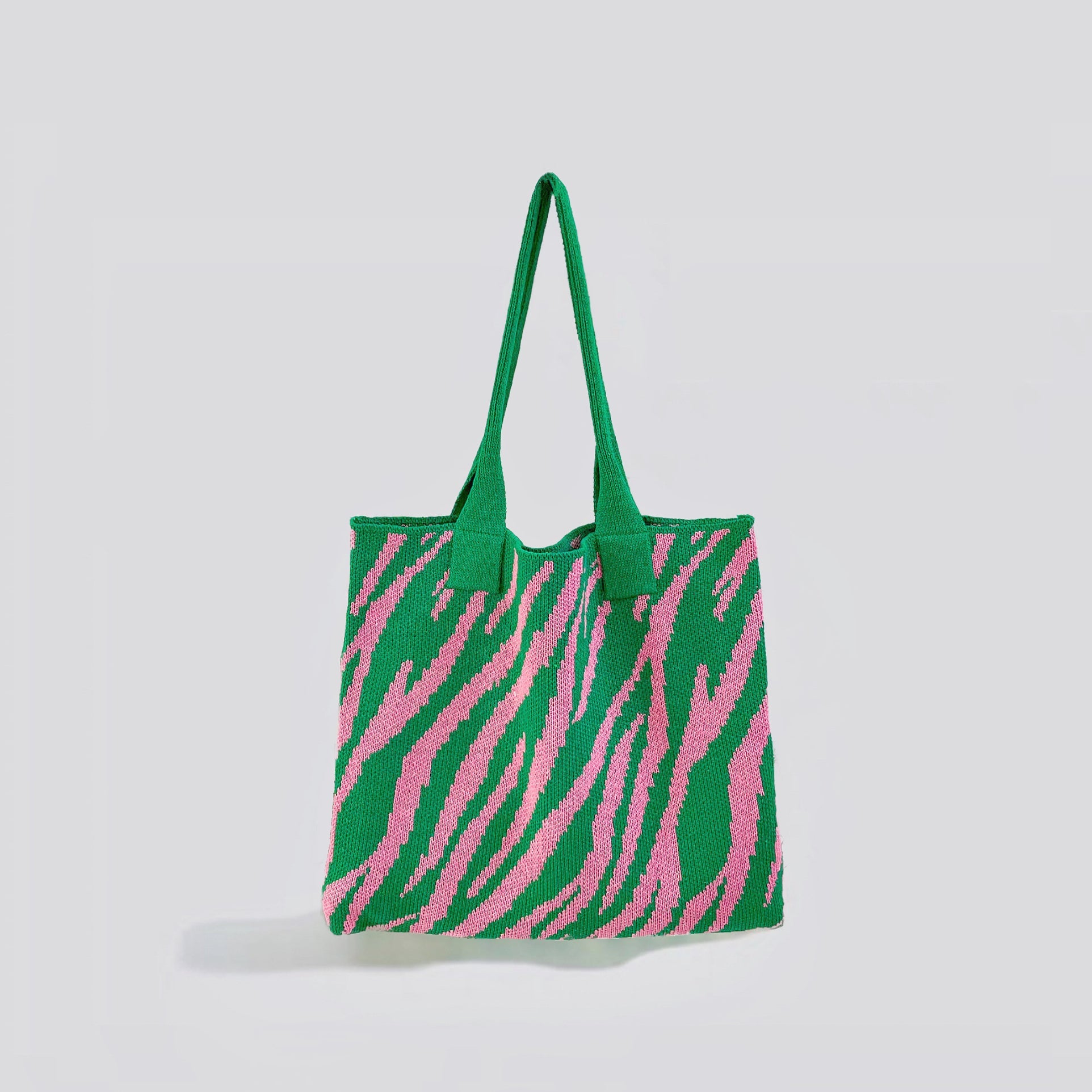 Angled view of  green and pink zebra print knitted tote bag made from blended yarn, easy for commuting and weekends.