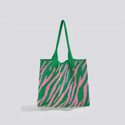 Angled view of  green and pink zebra print knitted tote bag made from blended yarn, easy for commuting and weekends.