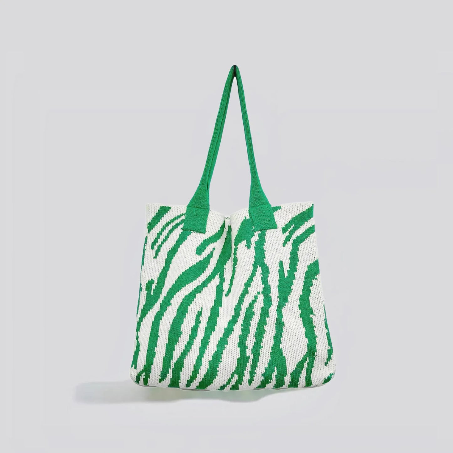 Flat lay of Zebra Print Knitted Tote Bag in white and green, great for everyday carry and travel.