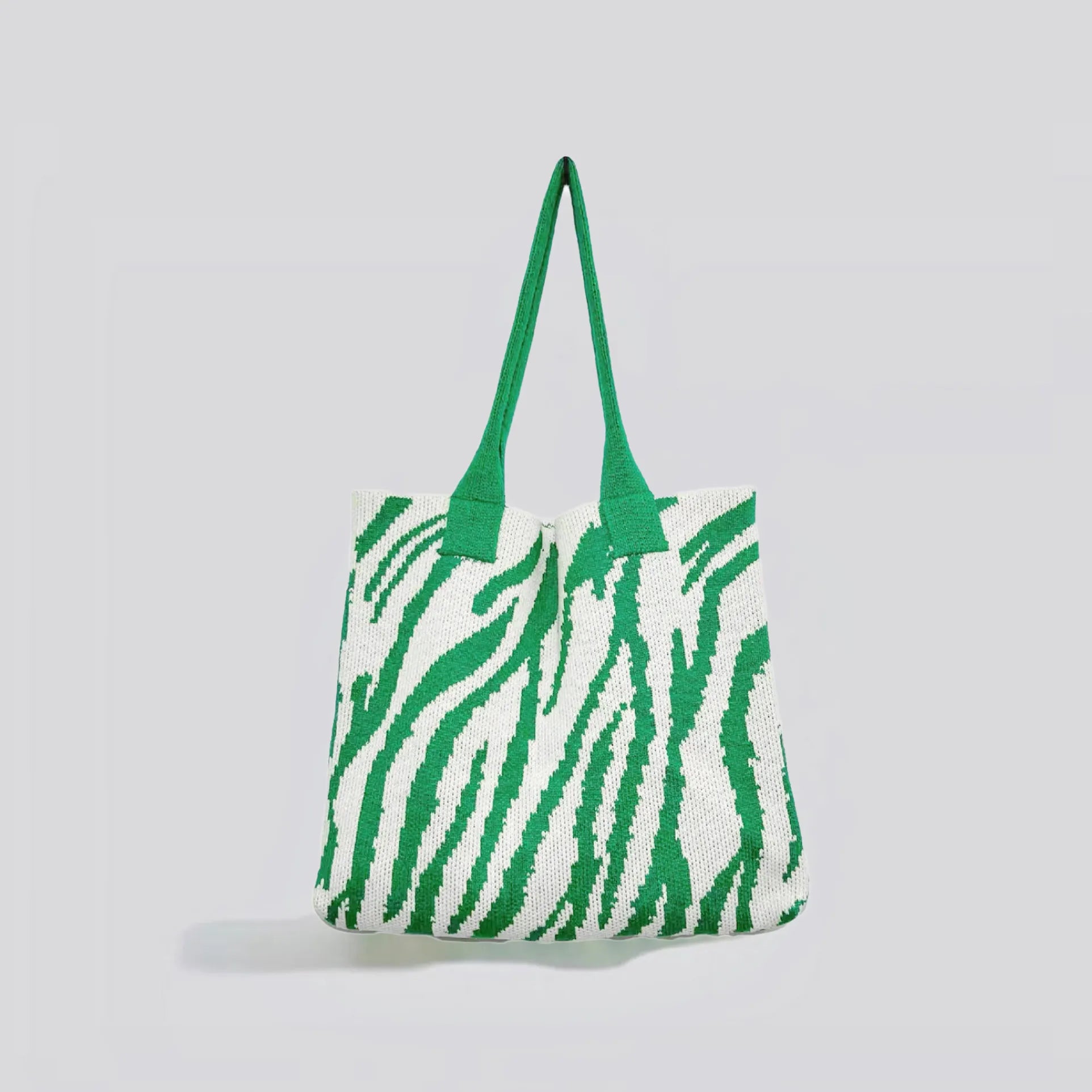 Flat lay of Zebra Print Knitted Tote Bag in white and green, great for everyday carry and travel.