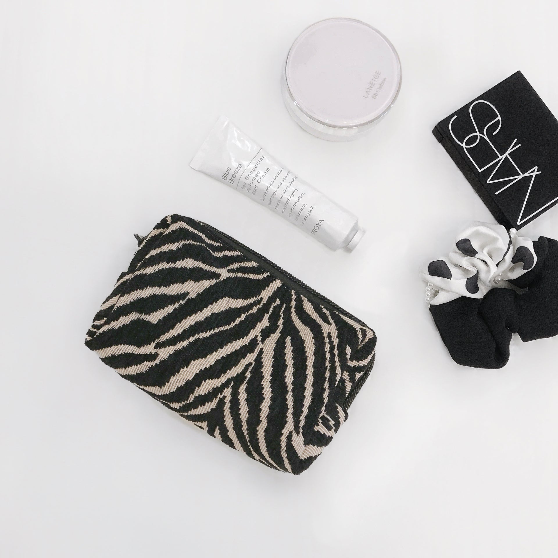 Flat lay of Zebra Print Makeup Bag in black, ideal for travel makeup and toiletries.