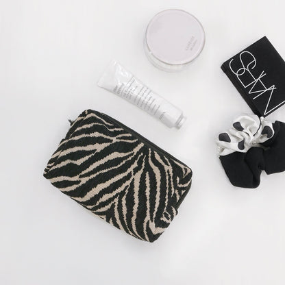 Flat lay of Zebra Print Makeup Bag in black, ideal for travel makeup and toiletries.